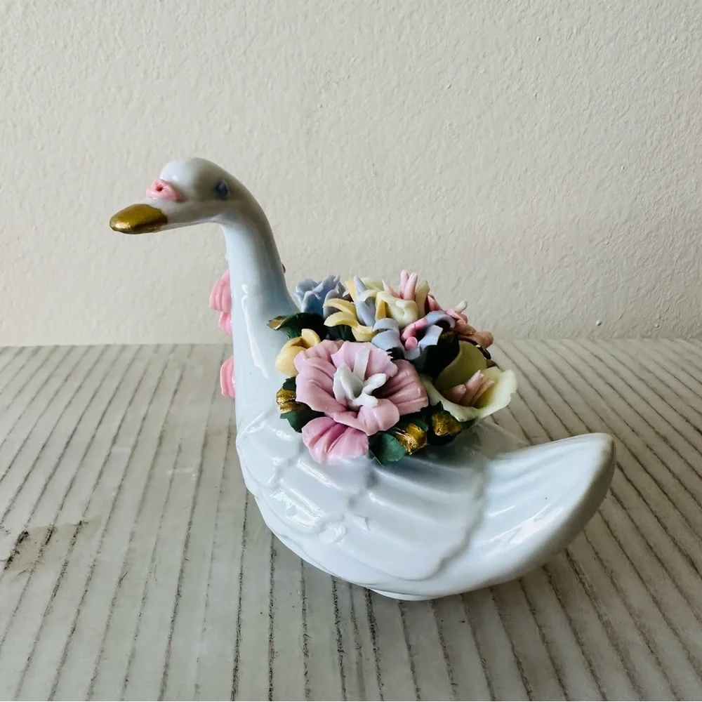 Beautiful little porcelain swan figurine with a back full of flowers!